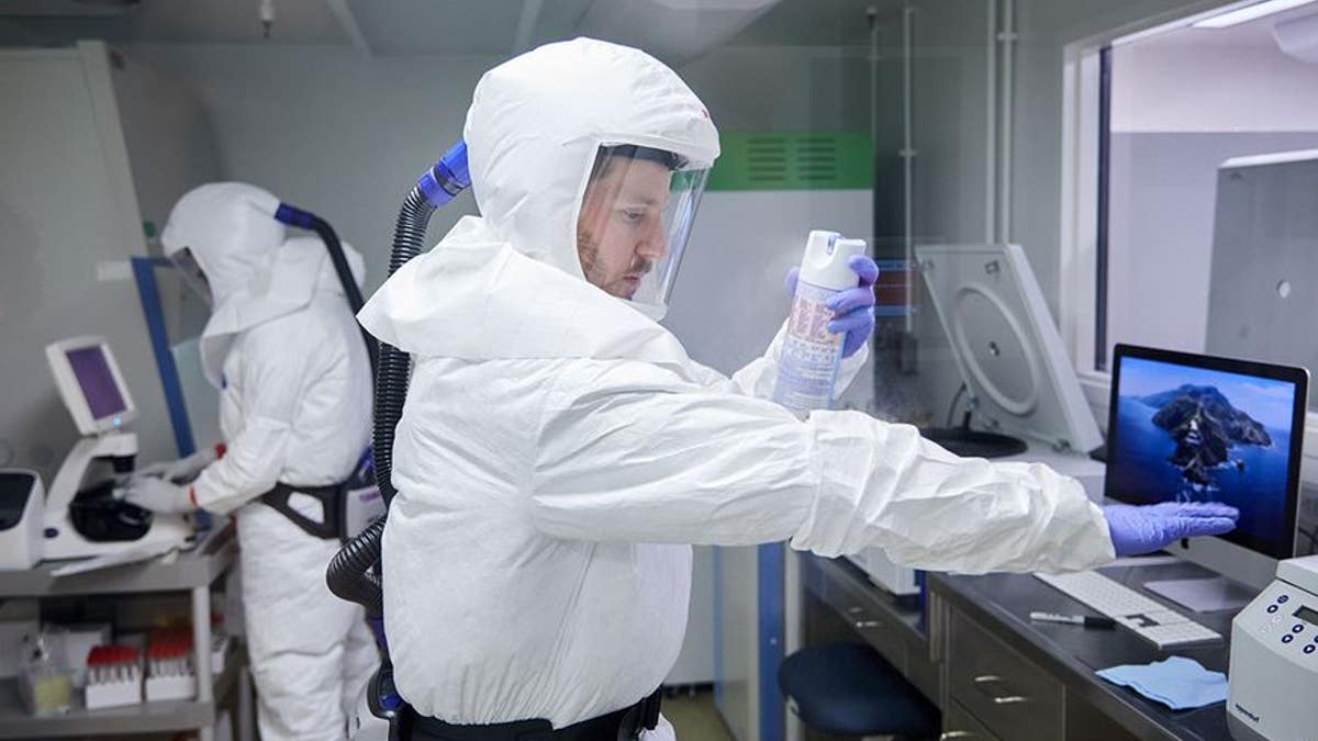 scientist in cleansuit works in lab