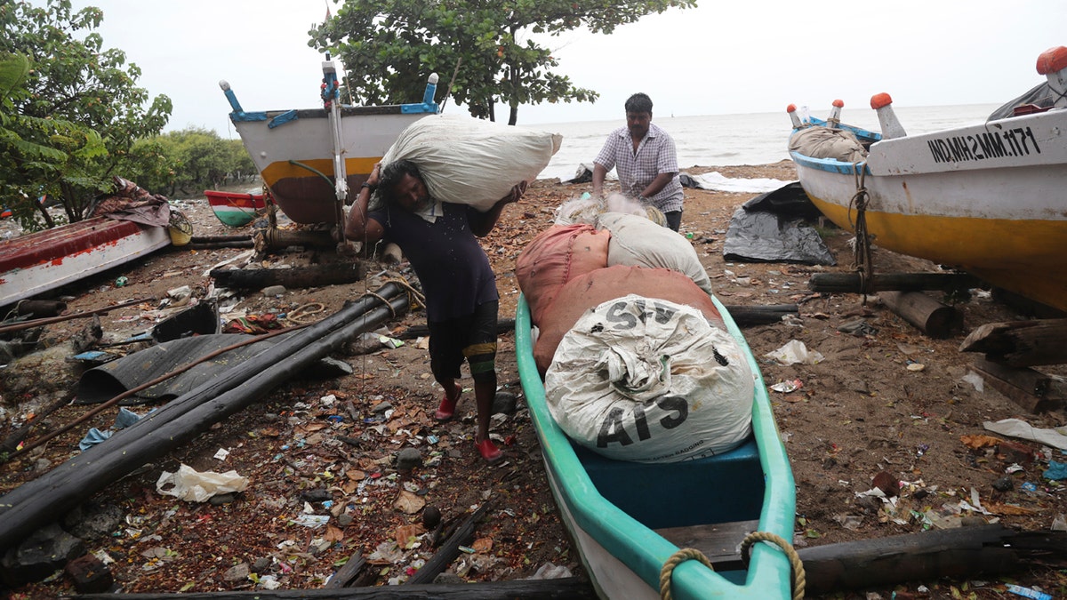 Fishermen load their nets onto a boat to keep them safe by the shores of the Arabian Sea in Mumbai, India, June 3.