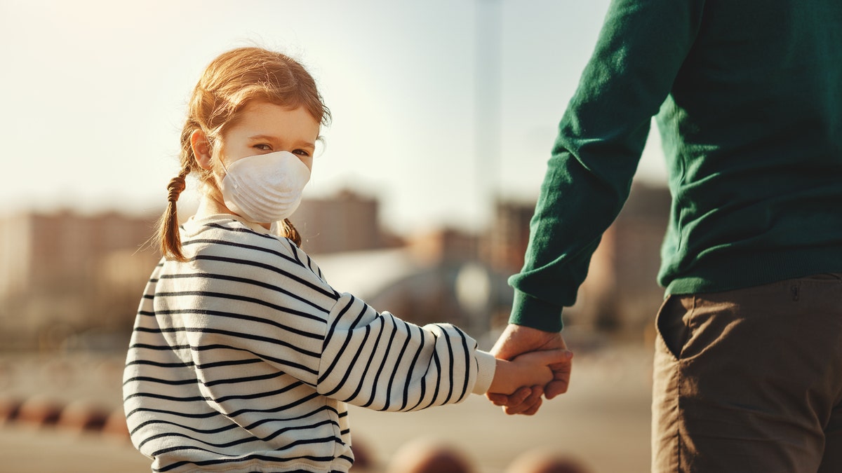 A young girl wearing a mask. 