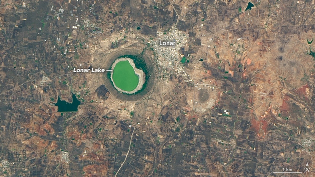 In this NASA photo from May 25, 2020, Lonar Lake can be seen with a green color at the surface.