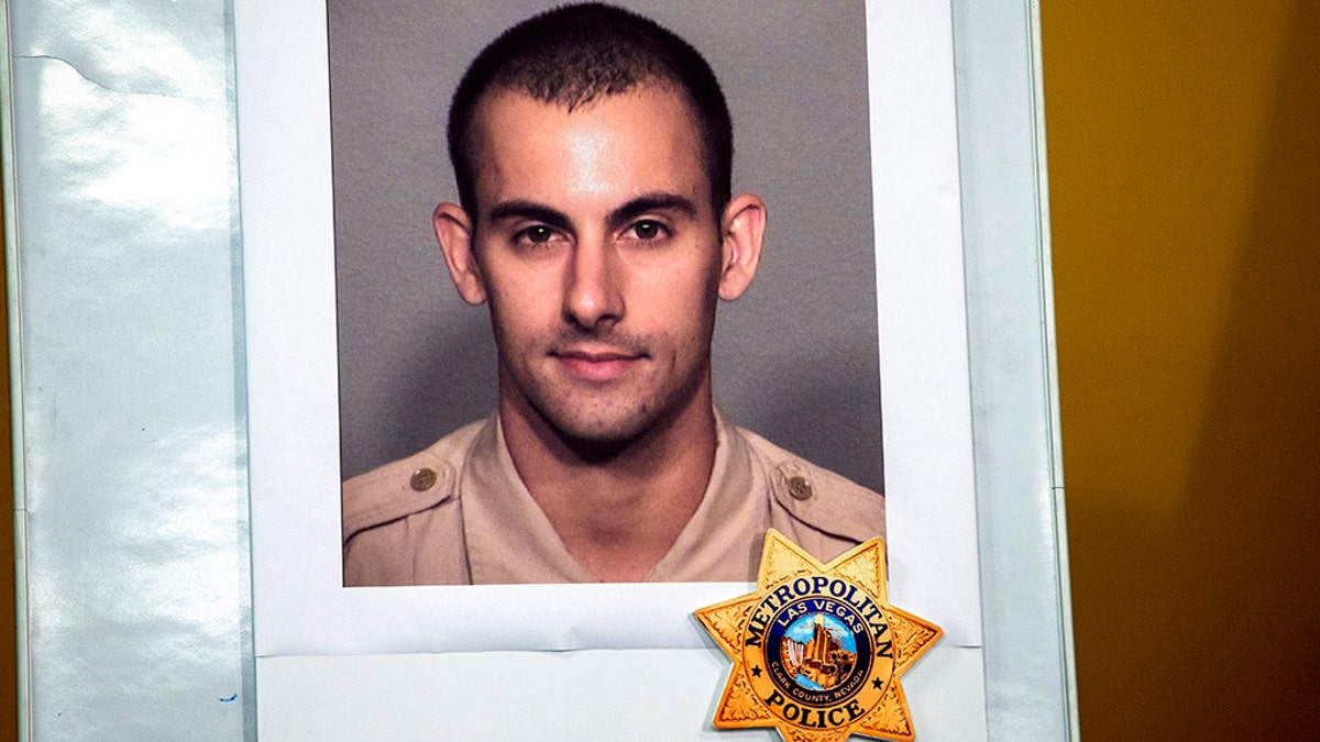 A photo of Las Vegas police officer Shay K. Mikalonis, 29, a four-year veteran of the department, is displayed during a media briefing at police headquarters in Las Vegas on Tuesday, June 2, 2020. Mikalonis was was shot Monday night in Las Vegas. (Steve Marcus/Las Vegas Sun via AP)
