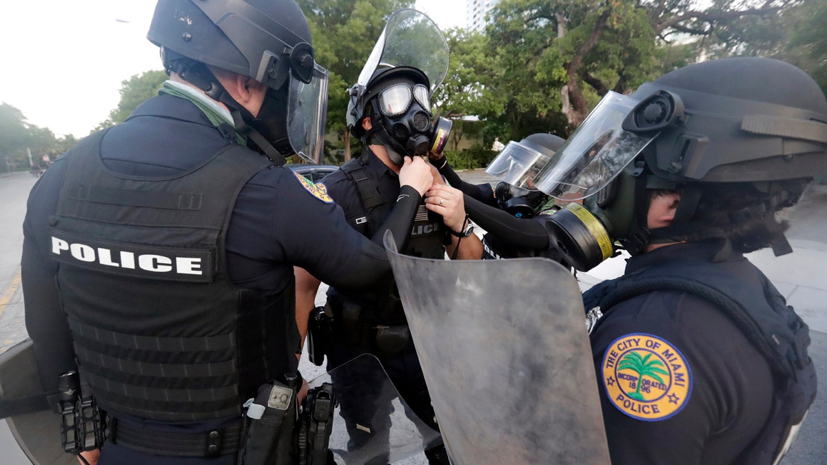 City of Miami police officers gear up as they prepare for any problems with protesters Sunday, May 31, 2020, in Miami. (AP Photo/Wilfredo Lee)