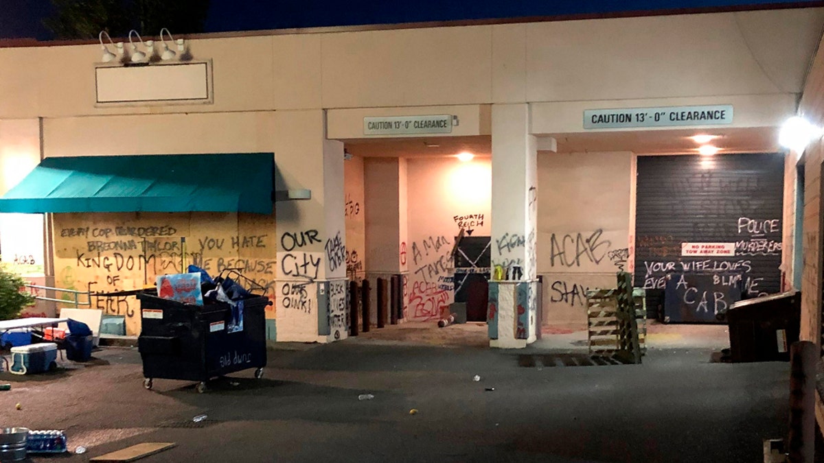 This Friday, June 26, 2020, photo released by the Portland Police Department shows damage after protests calling for an end to racial injustice and accountability for police in Portland, Ore. Some protesters set fire to a police precinct, vandalized businesses and tried to barricade police officers inside their station during a demonstration early Friday morning that ended with law enforcement using tear gas to disperse the crowd, authorities said. (Portland Police Department via AP)