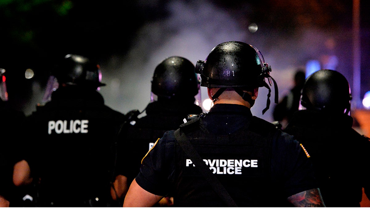 Police officers and National Guard soldiers make their way through a smoke filled street as they chase and confront protesters after curfew and after a peaceful Black Lives Matter rally in Providence, Rhode Island on June 5, 2020. (Photo by Joseph Prezioso / AFP) (Photo by JOSEPH PREZIOSO/AFP via Getty Images)