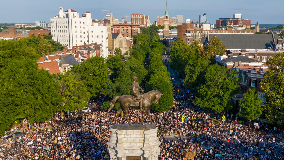 This Tuesday, June 2, 2020 file photo shows a large group of protesters gather around the statue of Confederate General Robert E. Lee on Monument Avenue near downtown in Richmond, Va.