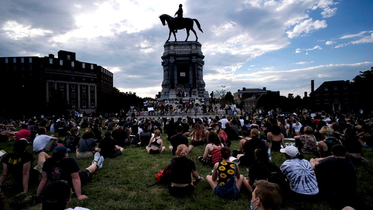 Protesters sit near the statue of Robert E. Lee on Monument Avenue in Richmond, Va., Wednesday, June 3, 2020. (Bob Brown/Richmond Times-Dispatch via AP)