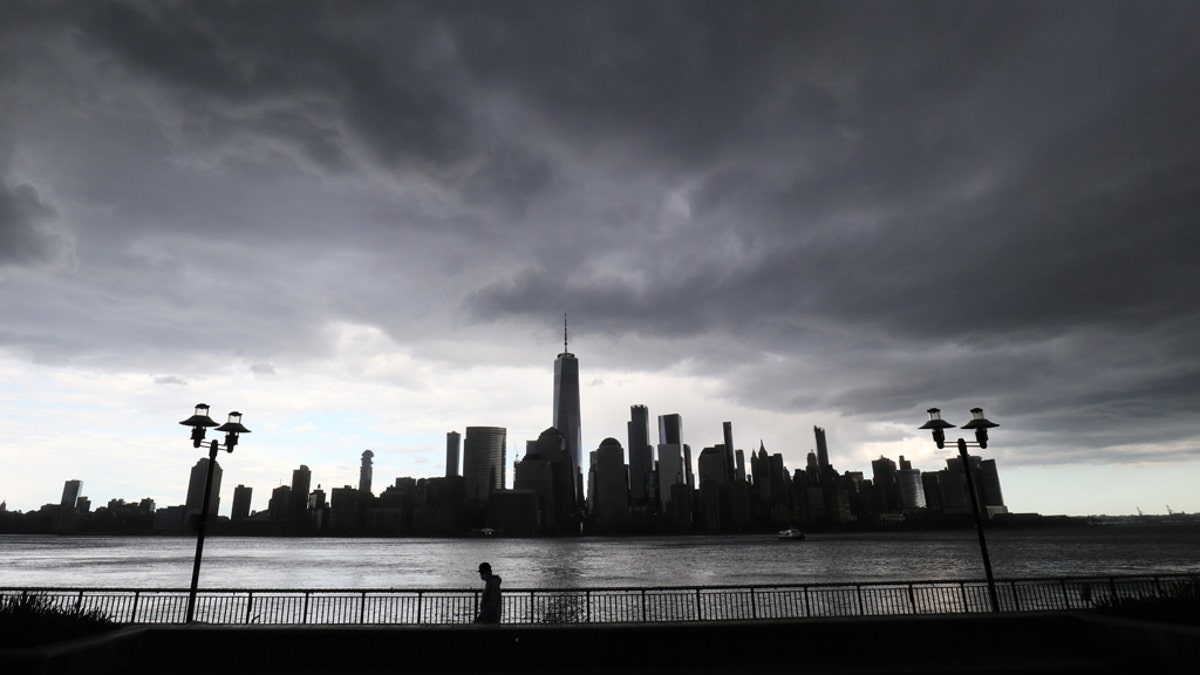A rainstorm passes over lower Manhattan and One World Trade Center in New York City on May 11, 2020, as seen from Jersey City, New Jersey.