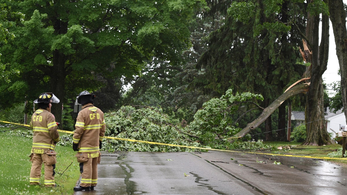 Concord firefighters work at the scene of a downed tree and power line on Main Street on June 10.
