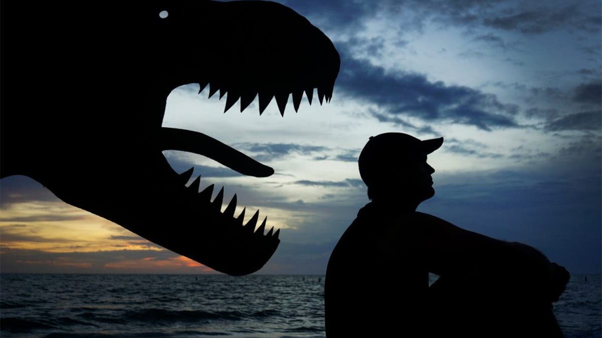 John Marshall surprised by a T Rex in a fun selfie created using cardboard in Maine. (Credit: SWNS)