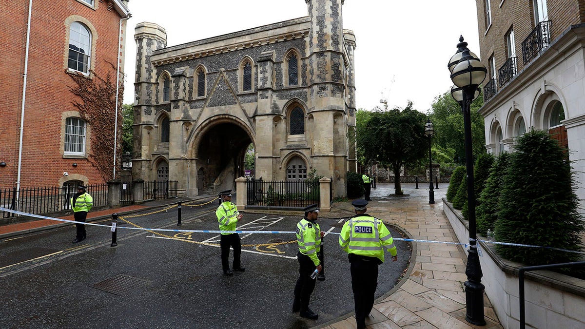 Police patrol the Abbey gateway of Forbury Gardens park in Reading town centre on Sunday following Saturday's stabbing attack in the gardens. (Jonathan Brady/PA via AP)