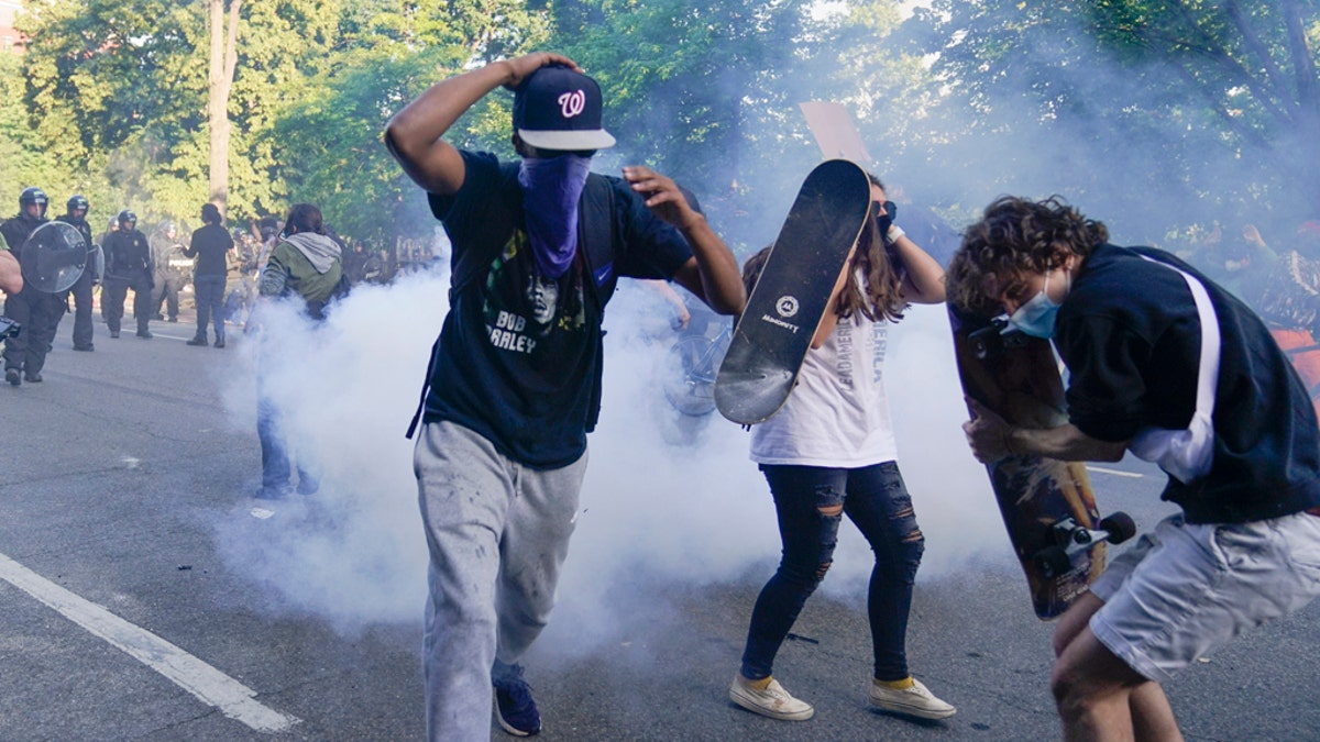 Demonstrators, who had gathered to protest the death of George Floyd, begin to run from tear gas used by police to clear the street near the White House in Washington, Monday, June 1, 2020. (AP Photo/Evan Vucci)