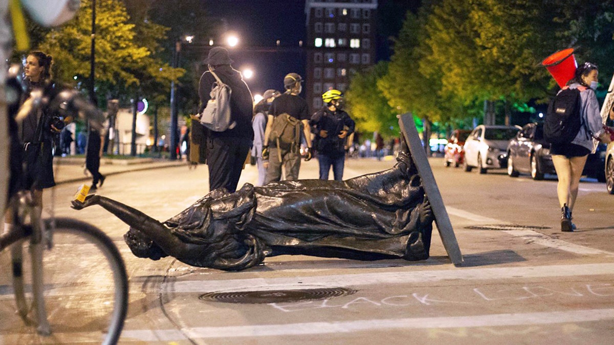 Wisconsin's "Forward" statue lies in the street on Capitol Square in Madison on Tuesday. The statue has since been recovered, officials said. (Emily Hamer/Wisconsin State Journal via AP)
