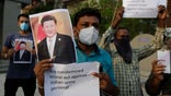 An Indian man holds a photograph of Chinese president Xi Jinping during a protest against China in Ahmedabad, India, Tuesday, June 16, 2020. At least three Indian soldiers, including a senior army officer, were killed in a confrontation with Chinese troops along their disputed border high in the Himalayas where thousands of soldiers on both sides have been facing off for over a month, the Indian army said Tuesday. (AP Photo/Ajit Solanki)