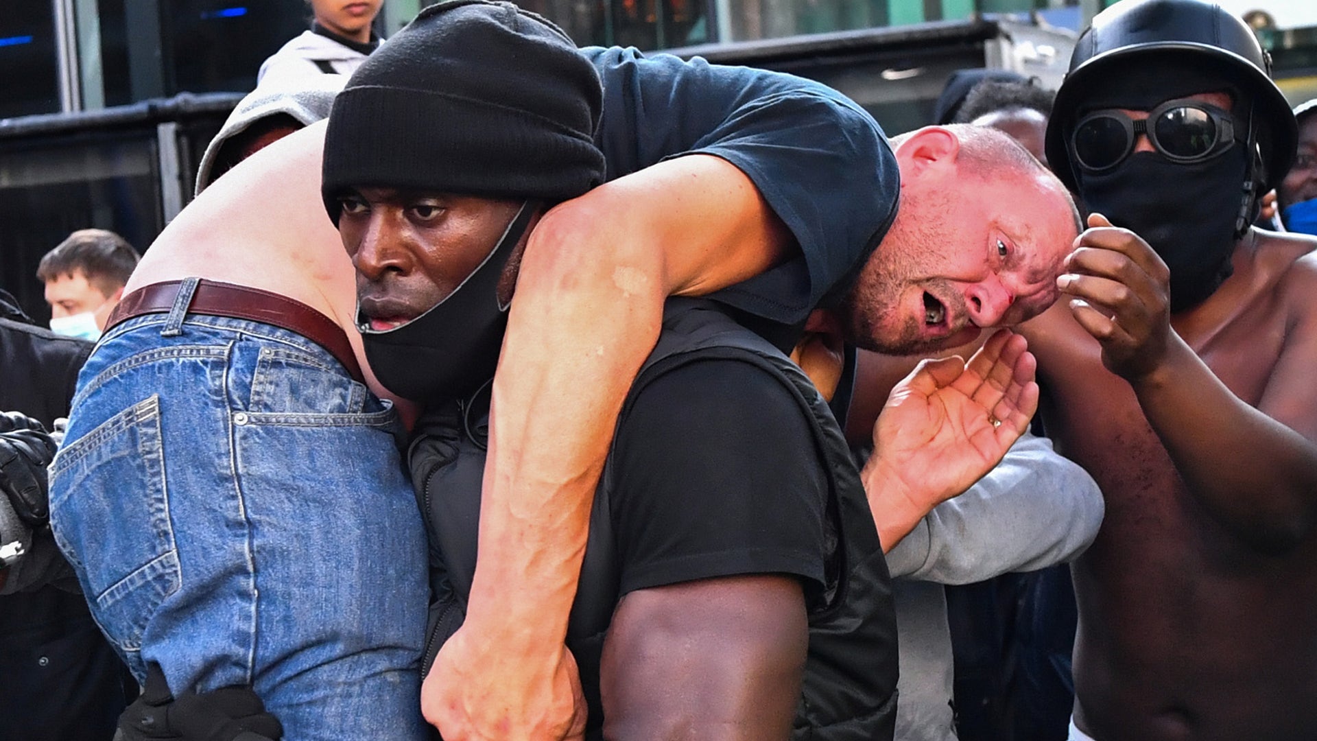 Protester Patrick Hutchinson carries an injured counter-protester to safety, near the Waterloo station during a Black Lives Matter protest in London, June 13, 2020. 