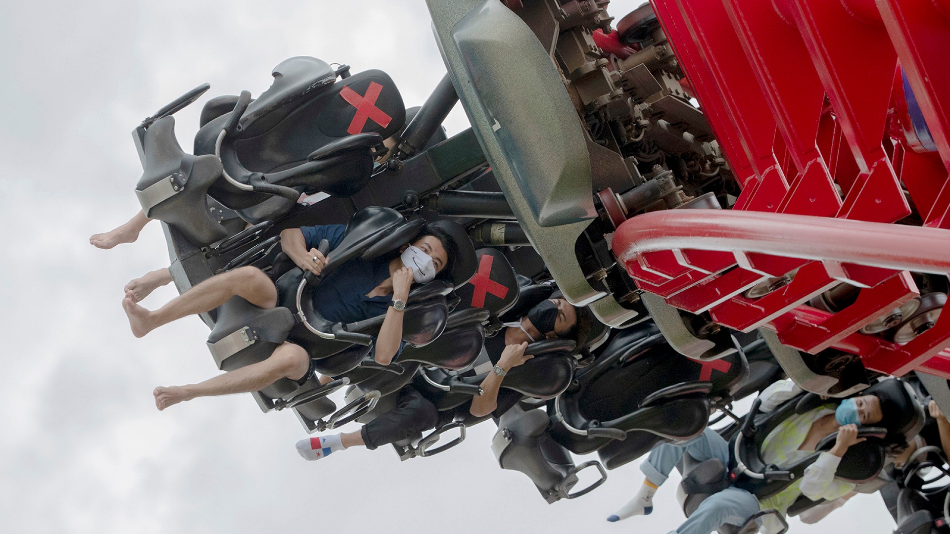 Visitors wear their face masks to help curb the spread of the coronavirus, as they ride the "Vortex" rollercoaster at the recently reopened Siam Amazing Park in Bangkok, Thailand, June 17, 2020. 