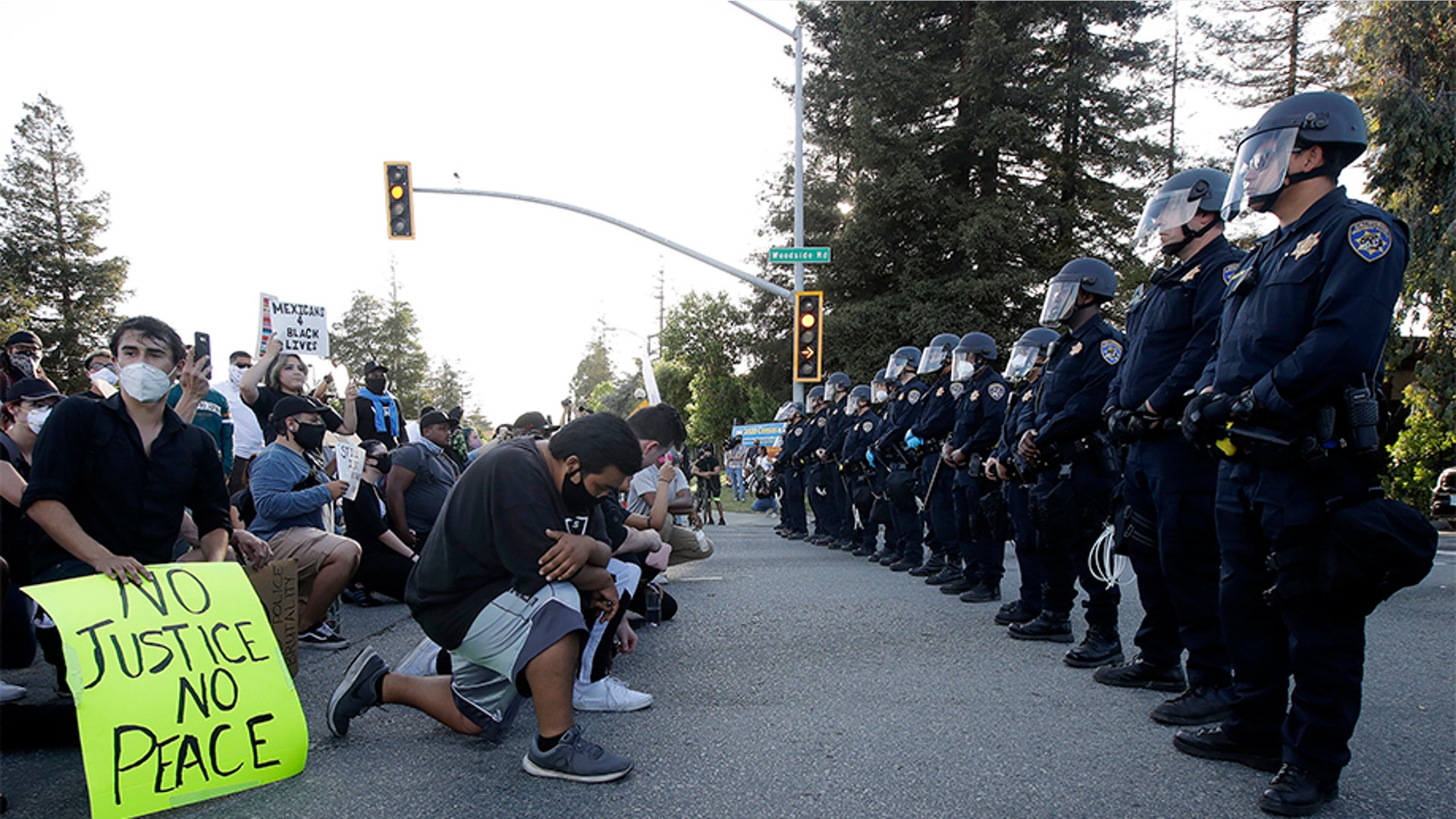 People kneeling in front of a line of California Highway Patrol officers in Redwood City, Calif., on June 2.