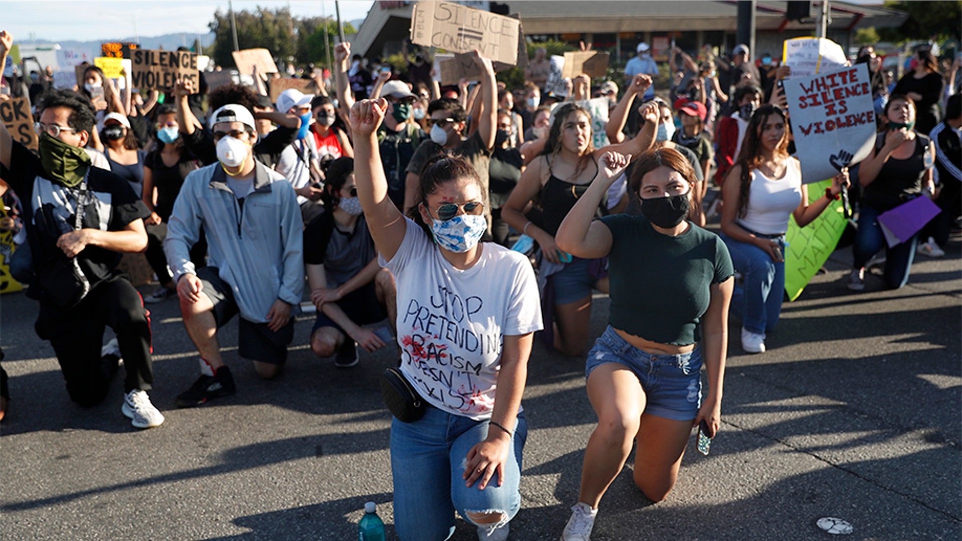 Protesters kneeling and raising their arms in Redwood City, Calif., on June 2.