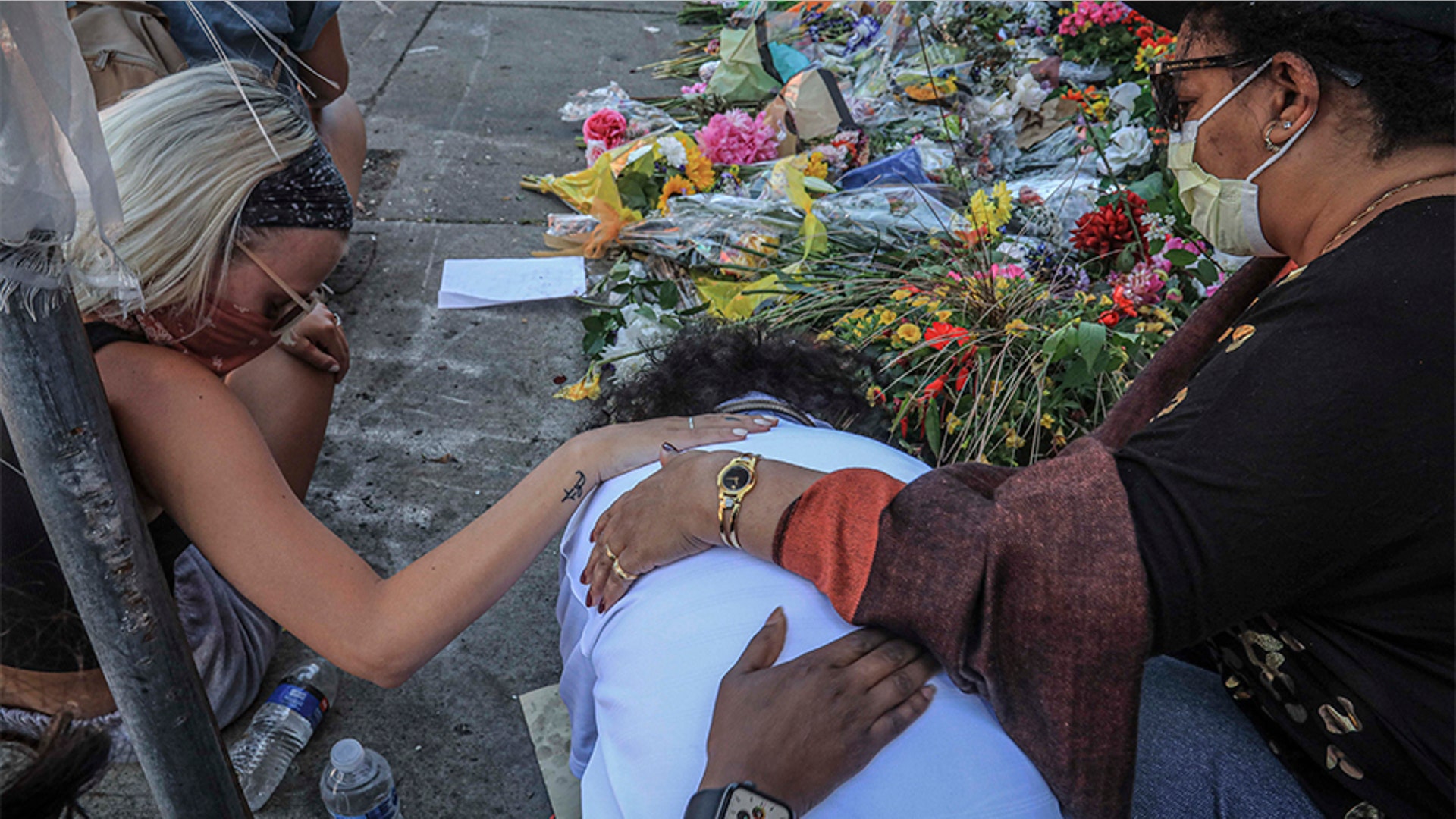 Alganesh Hadgu, center, in tears during a visit to the public memorial in Minneapolis for George Floyd, at the spot where he died after an encounter with police.