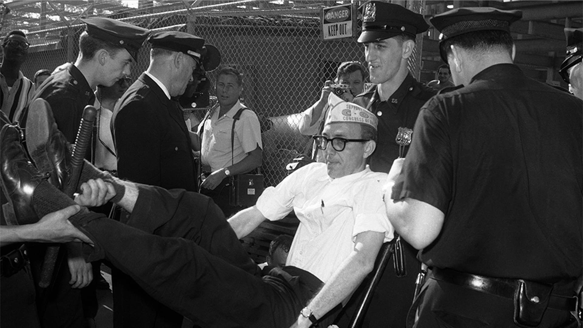 New York City police carrying a sit-down demonstrator from the entrance to a hospital in Brooklyn on July 19, 1963. Sixteen demonstrators were arrested after they staged a sit-down attempting to block trucks from entering the medical center under construction. Demonstrators represented the Congress of Racial Equality seeking employment of more African-American and Puerto Rican workers on the construction project and others.