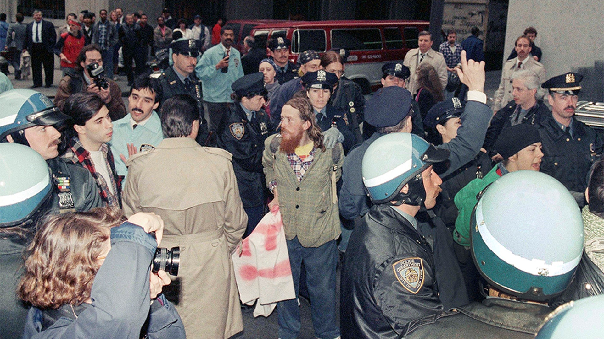 New York City police taking into custody some of the demonstrators arrested on Monday, May 1, 1989, on Wall Street as part of a May Day protest in New York. The demonstrators called themselves "Resist to Exist."