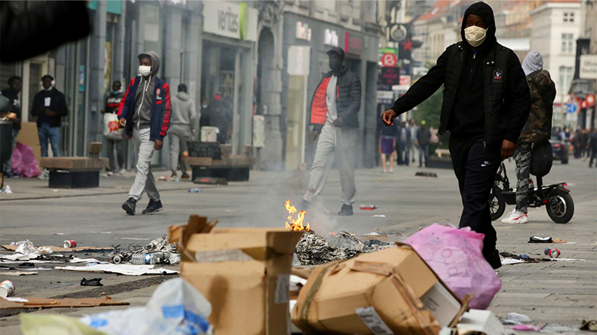 Protesters and others burning trash and ransacking a popular shopping street in Brussels. 