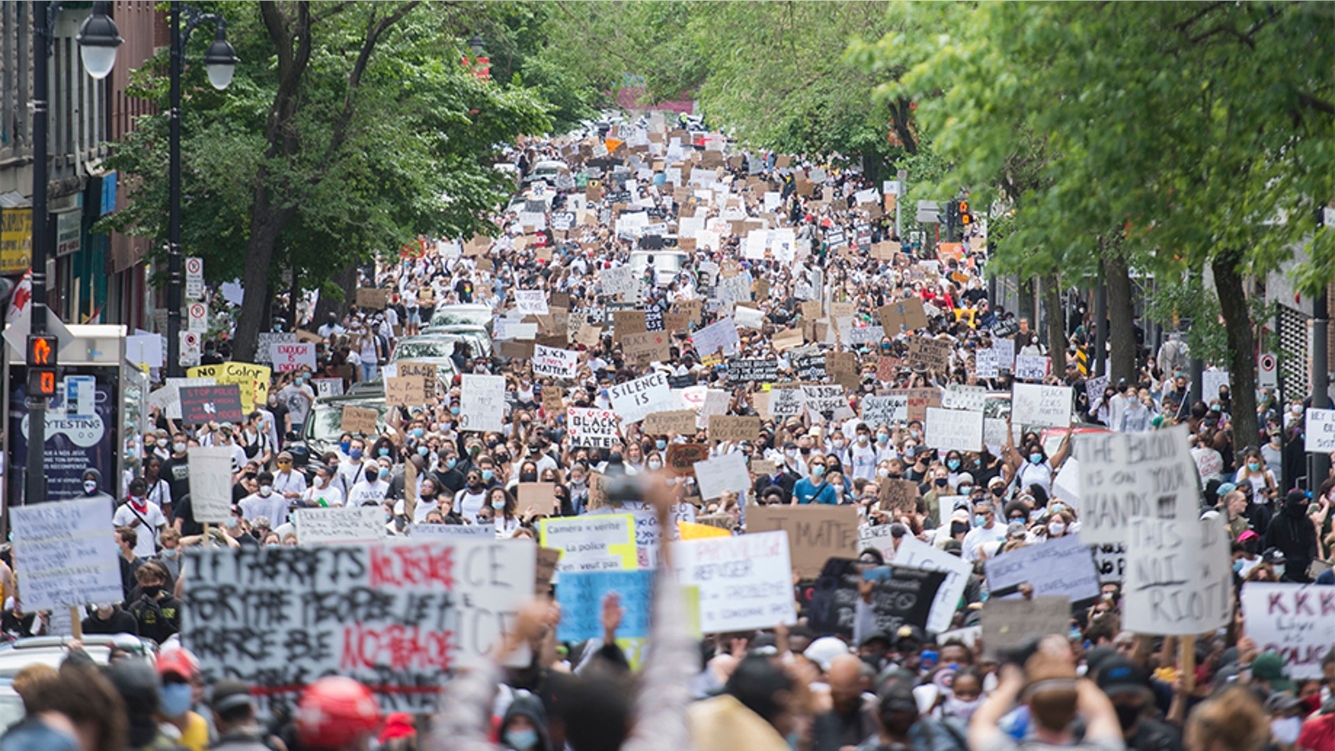 People holding up signs during a demonstration calling for justice for the death of George Floyd, in Montreal, Canada. 