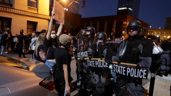 Viral photo shows Louisville cop protected by black protesters when separated from squad during riot