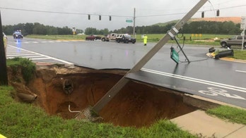 Sinkhole in Florida opens up along roadway, taking down traffic lights and causing crash