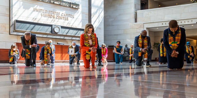 House Speaker Nancy Pelosi of Calif., center, and other members of Congress, kneel and observe a moment of silence at the Capitol's Emancipation Hall, Monday, June 8, 2020, on Capitol Hill in Washington, reading the names of George Floyd and others killed during police interactions.