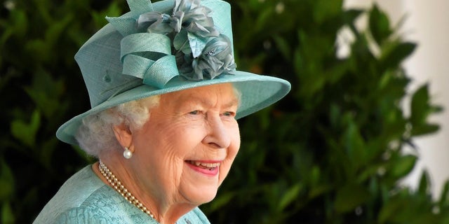 Britain's Queen Elizabeth II reacts as she looks out during a ceremony to mark her official birthday at Windsor Castle in Windsor, England, Saturday June 13, 2020.