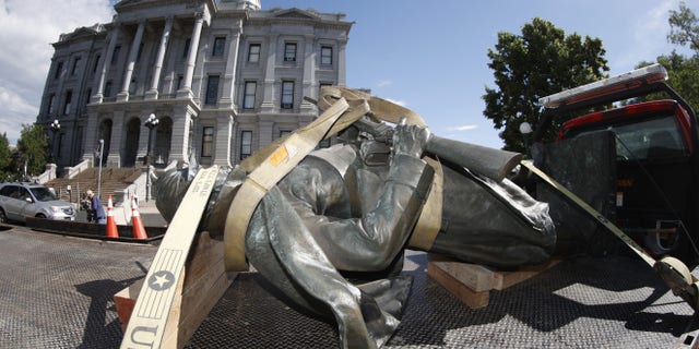 The Civil War Monument statue is strapped on the back of a flatbed tow truck after it was toppled from its pedestal in front of the State Capitol Thursday in Denver, Colorado. (AP)