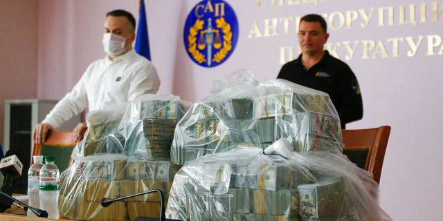 Ukraine's Anti-Corruption Prosecutor Nazar Kholodnytsky, left, and National Anti-Corruption Bureau chief Artem Sytnik displaying the massive piles of cash at an anti-corruption prosecutor's office in Kiev on Saturday.