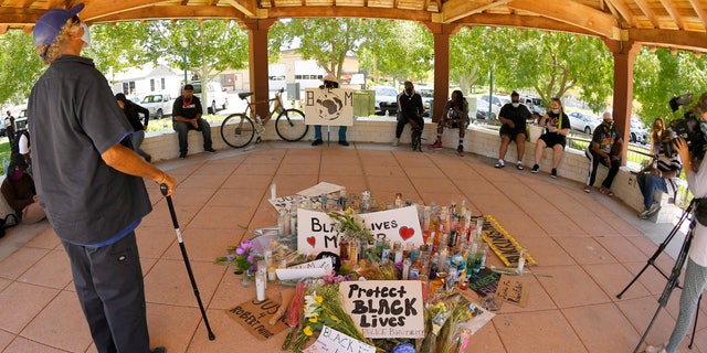 A man stands at a memorial as where protesters gathered at the site where Robert Fuller was found hanged, Monday, June 15, 2020, in Palmdale, Calif. State and federal authorities will monitor the investigation into the death of Fuller, a black man found hanging from a tree in the Southern California city of Palmdale, officials said Monday following large weekend protests. (AP Photo/Mark J. Terrill)