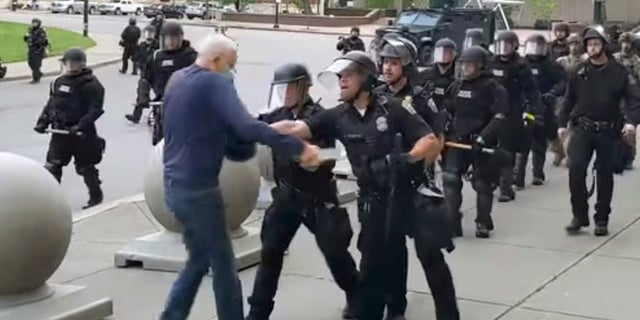 A Buffalo police officer appears to shove Martin Gugino, who walked up to police during a June 4 demonstration. Video from WBFO shows Gugino appearing to hit his head on the pavement, with blood leaking out as officers walk past to clear Niagara Square. Buffalo police initially said in a statement that a person “was injured when he tripped & fell,” WIVB-TV reported. (Mike Desmond/WBFO via AP)