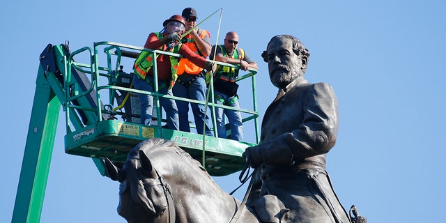 An inspection crew from the Virginia Department of General Services takes measurements as they inspect the statue of Confederate Gen. Robert E. Lee on Monument Avenue Monday June 8, 2020, in Richmond, Va. Virginia Gov. Ralph Northam has ordered the removal of the statue. (AP Photo/Steve Helber)