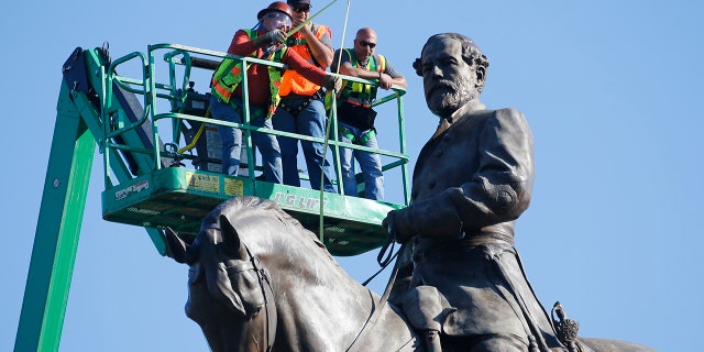 An inspection crew from the Virginia Department of General Services takes measurements as they inspect the statue of Confederate Gen. Robert E. Lee on Monument Avenue Monday June 8, 2020, in Richmond, Va. (AP Photo/Steve Helber)