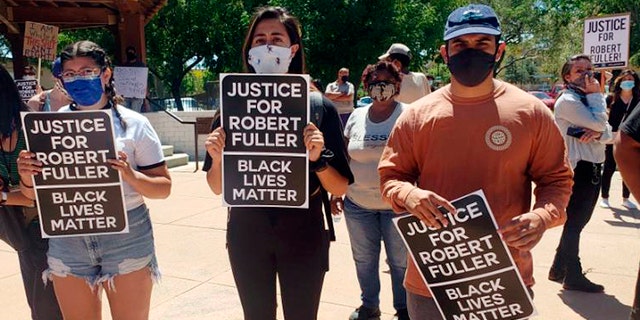 In this Saturday, June 13, 2020, photo provided by Najee Ali, people gather around the park where the body of Robert Fuller was found dead Wednesday, June 10 in Poncitlan Square in Palmdale, Calif. People marched to demand an investigation into the death of 24-year-old Robert Fuller, who was found hanging from a tree early Wednesday near City Hall. The protesters marched from where the body was found to a sheriff's station, with many carrying signs that said "Justice for Robert Fuller." (Najee Ali via AP)