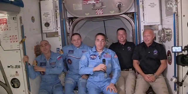 This photo provided by NASA shows Bob Behnken and Doug Hurley, far right, joining the crew at the International Space Station, after the SpaceX Dragon capsule pulled up to the station and docked Sunday, May 31, 2020. The Dragon capsule arrived Sunday morning, hours after a historic liftoff from Florida. It's the first time that a privately built and owned spacecraft has delivered a crew to the orbiting lab. (NASA via AP)