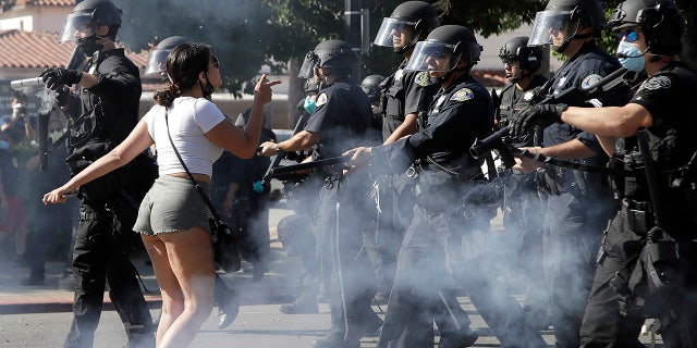 A protester confronts San Jose police as they advance on Friday, May 29, 2020, in San Jose, Calif., as people demonstrate nationwide in response to George Floyd dying while in police custody on Memorial Day, in Minneapolis. (AP Photo/Ben Margot)