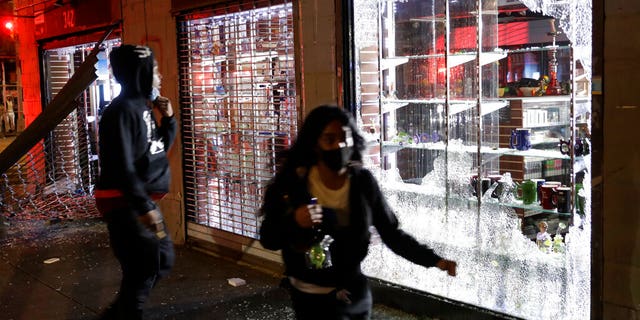 People run as police arrive to the scene of a broken into smoke shop in New York, Monday, June 1, 2020. A fourth day of protests against police brutality kept New York City on edge Sunday, as thousands of people marched and many protesters and officers tried to keep the peace after days of unrest that left police cars burned and hundreds of people under arrest. (AP Photo/Seth Wenig)