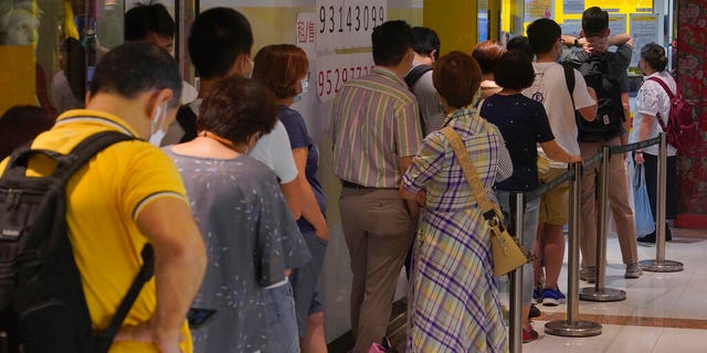 People queue up outside the DHL Express store in Hong Kong, Monday, June 1, 2020.