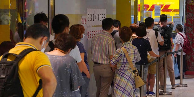 People queue up outside the DHL Express store in Hong Kong, Monday, June 1, 2020.