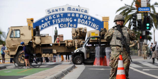 Un membre de la Garde nationale se tient devant le bâtiment de la jetée de Santa Monica le lundi 1er juin 2020 à Santa Monica, en Californie, un jour après les troubles et les protestations contre la mort de George Floyd, un homme noir qui était en garde à vue à Minnéapolis.  (AP Photo/Marcio José Sanchez)