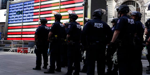 Police officers in riot gear stand by in Times Square during a protest in Manhattan in New York, Monday, June 1, 2020. New York City imposed an 11 p.m. curfew Monday as the nation's biggest city tried to head off another night of destruction erupting amid protests over George Floyd's death. 