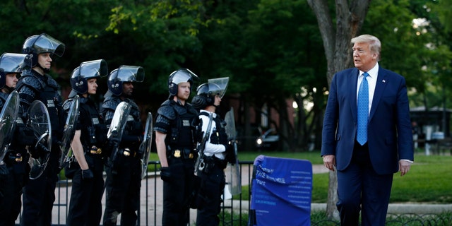 President Donald Trump walks past police in Lafayette Park after visiting outside St. John's Church across from the White House Monday, June 1, 2020, in Washington. Part of the church was set on fire during protests on Sunday night. (AP Photo/Patrick Semansky)
