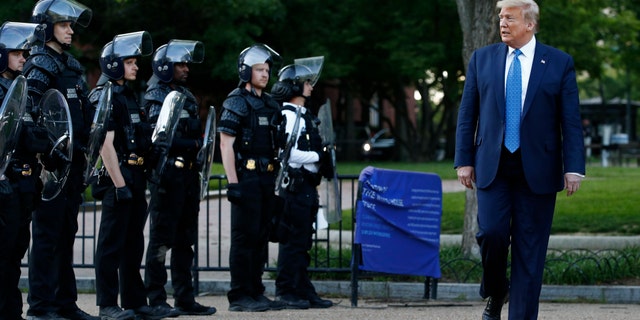 President Donald Trump walks past police in Lafayette Park after visiting outside St. John's Church across from the White House Monday, June 1, 2020, in Washington. Part of the church was set on fire during protests on Sunday night. (AP Photo/Patrick Semansky)