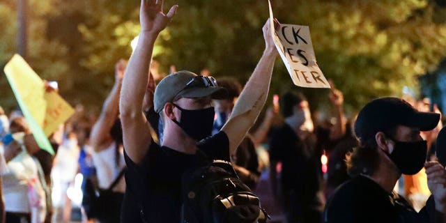 A protester raises his hands over the deaths of George Floyd and Breonna Taylor, Monday, June 1, 2020, in Louisville, Ky. Taylor, a black woman, was fatally shot by police in her home in March and Floyd, a black man, died after being restrained by Minneapolis police officers on May 25.