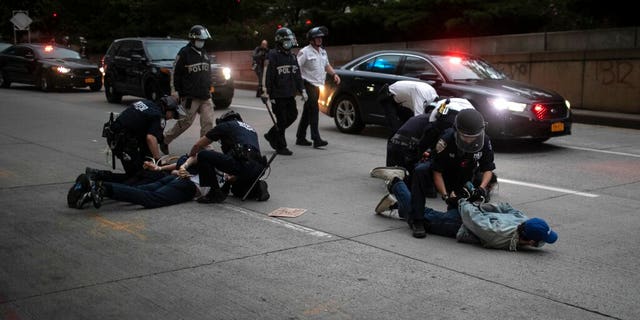 A polícia prende manifestantes que se recusam a sair das ruas durante um toque de recolher imposto enquanto marcham em um comício pedindo justiça pela morte de George Floyd na terça-feira, 2 de junho de 2020, em Nova York. Floyd morreu após ser contido pelos policiais de Minneapolis em 25 de maio.