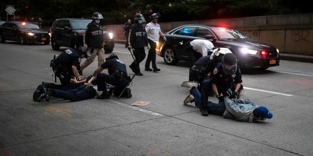 Police arrest protesters refusing to get off the streets during an imposed curfew while marching in a rally calling for justice over the death of George Floyd Tuesday, June 2, 2020, in New York. Floyd died after being restrained by Minneapolis police officers on May 25.