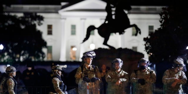 A line of DC National Guard members stand in Lafayette Park as demonstrators gather to protest the death of George Floyd near the White House in Washington. (AP Photo/Alex Brandon)